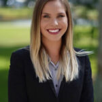 Portrait of Gabriella Penalta, attorney, smiling outdoors in a professional blazer.